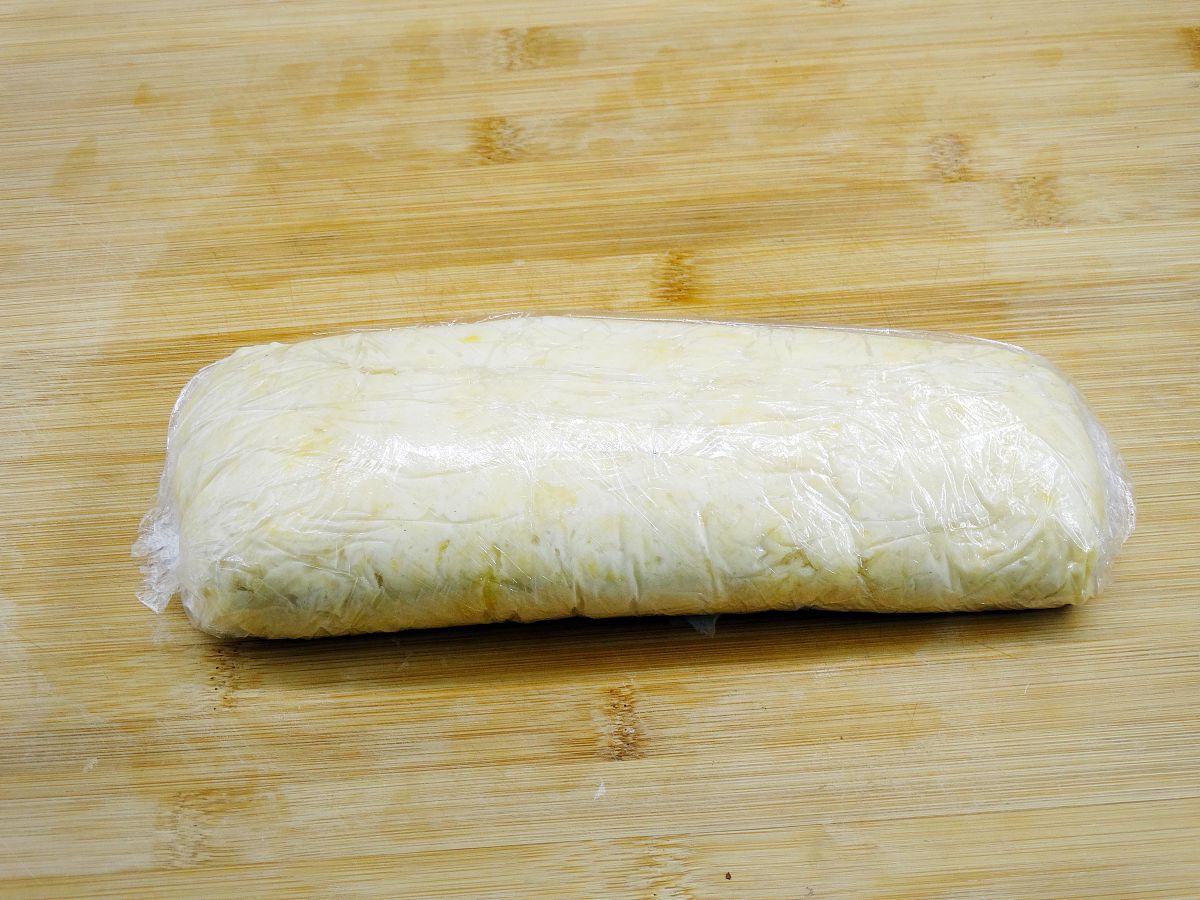 图为香酥小油条的制作过程 面团揉成长条状,用保鲜膜包紧,饧面20分钟.
