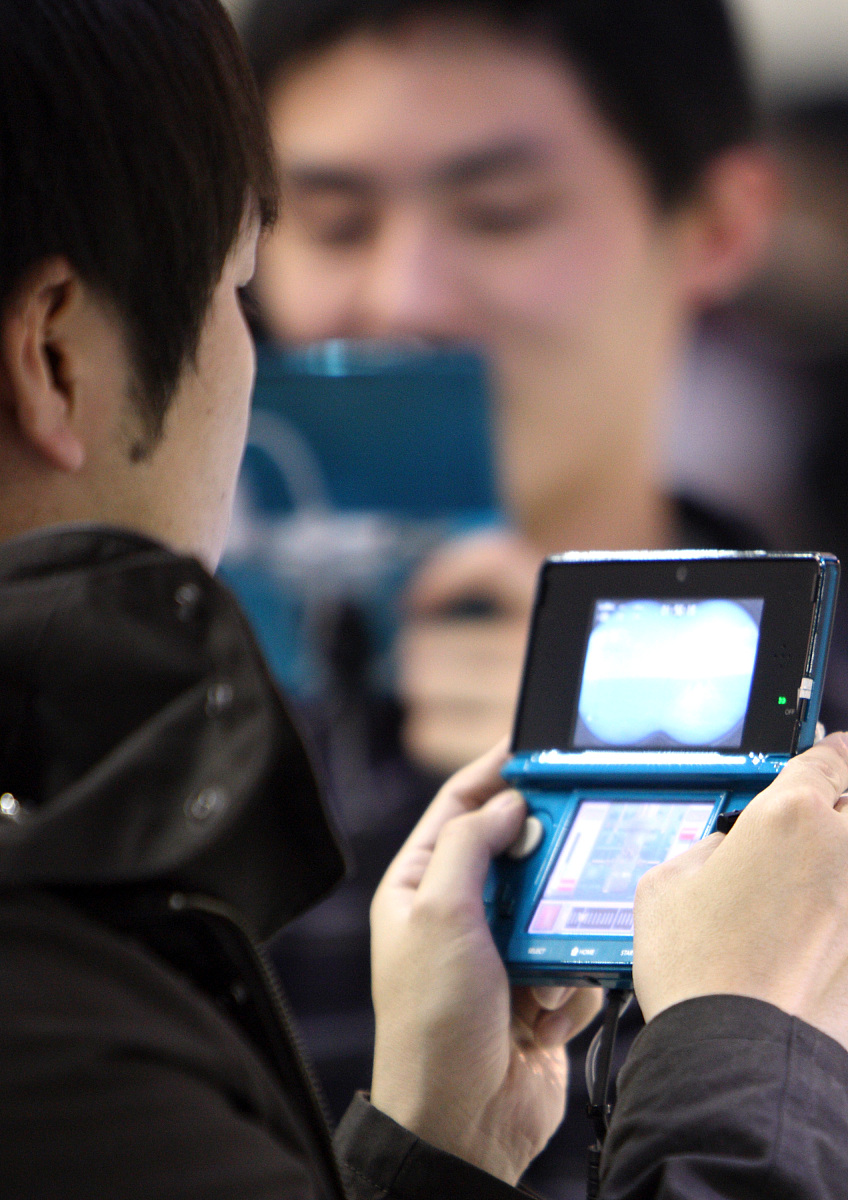2011年1月6日,日本千叶,参观者正在试用任天堂公司的3ds掌上游戏机.任