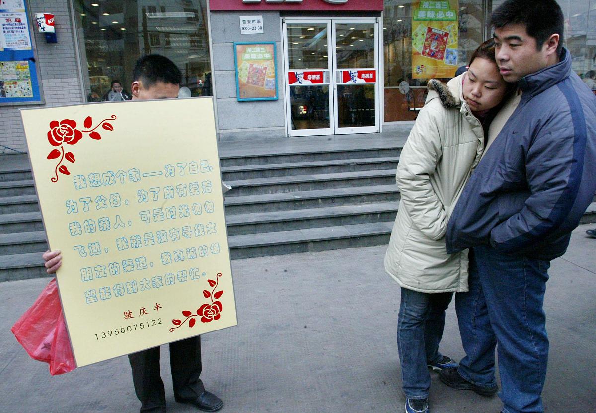 2004年2月12日,杭州物美超市门前一名男子举着牌子征女友.      该男