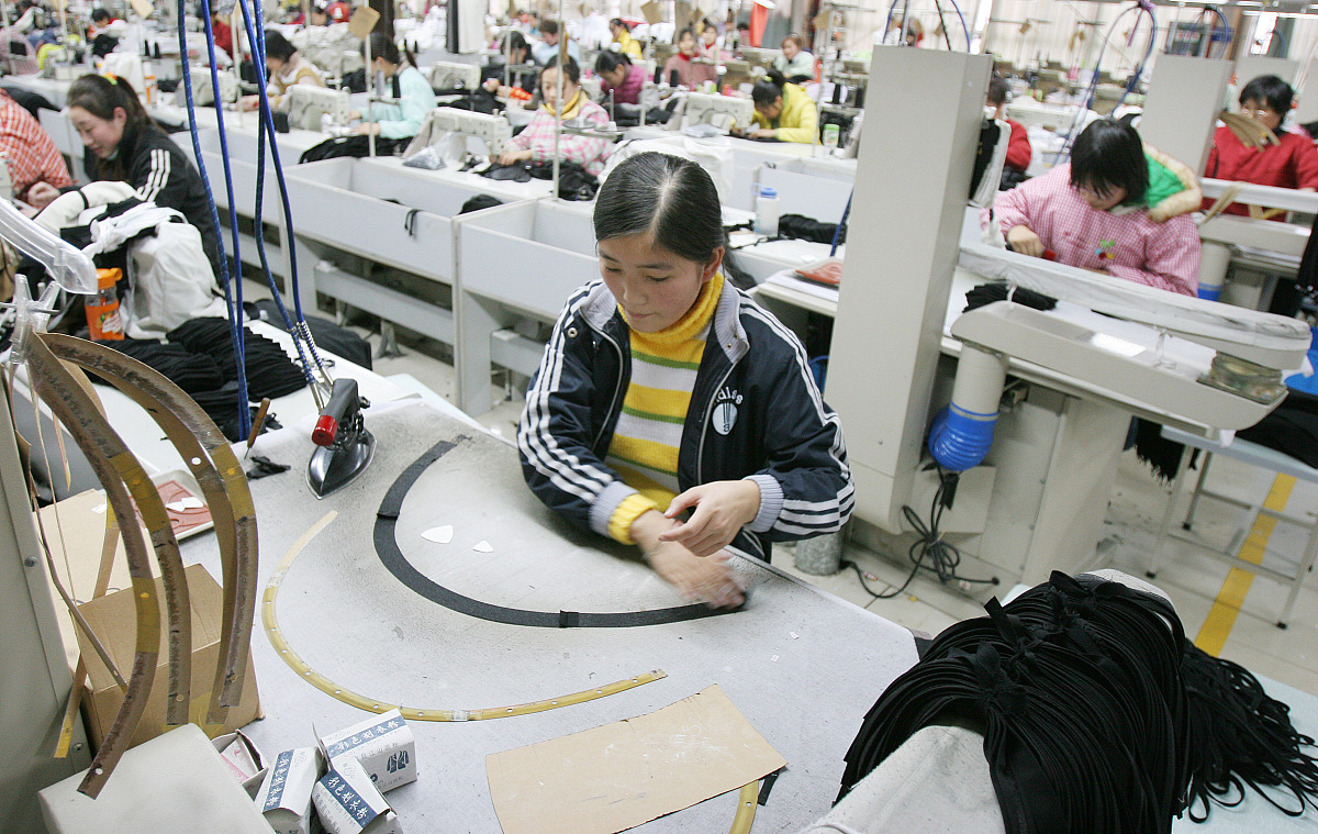 ***_***  2009年1月3日,工人在江苏南通一服装企业生产车间忙碌. +++_