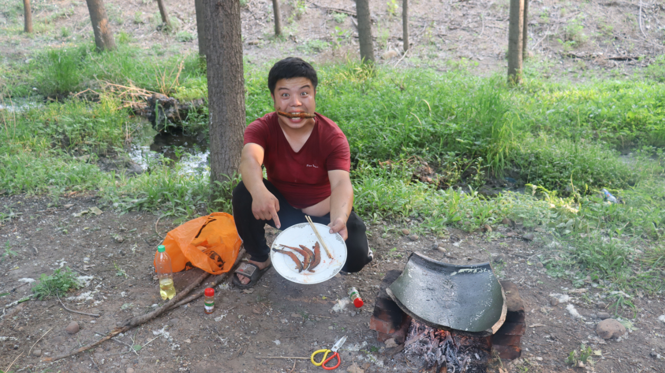 农村小伙野外用瓦缸煎泥鳅,出锅后焦黄酥脆,这味道可真美