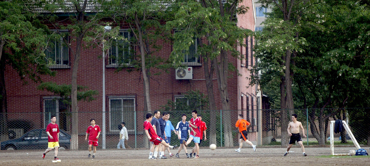 2007年5月24日,辽宁沈阳,业余足球队员们在一场雨后泥泞的场地内比赛.
