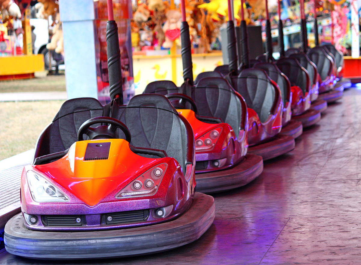 a line of bumper cars at an amusement fair