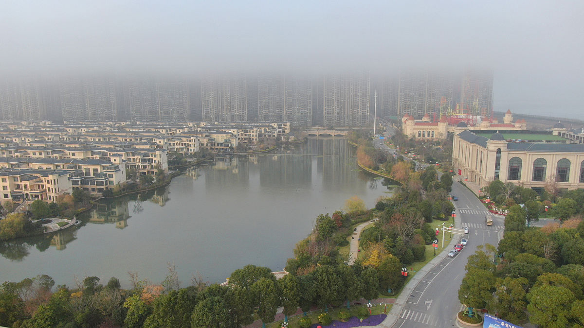2019年12月16日,航拍下的启东市海边风光迷人,建筑在雾中若隐若现,宛