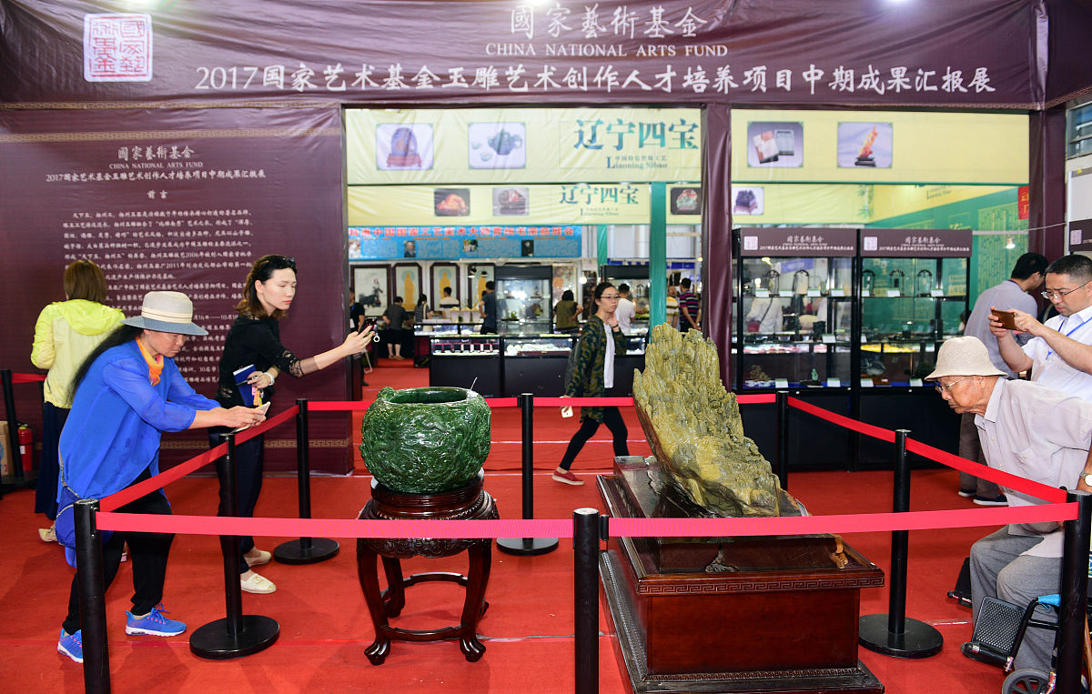 2018年6月15日,江苏扬州,展会上市民观看展览,玉器,漆器,瓷器等展品吸