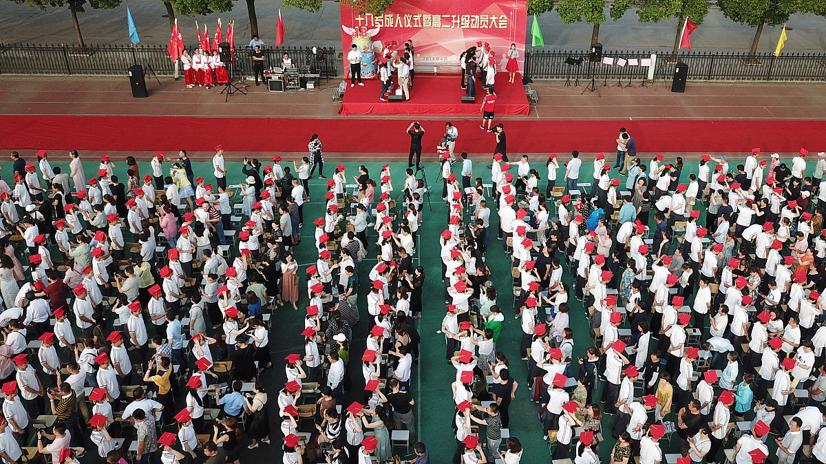 ***_***2018年6月15日,在江苏扬州第一中学成人礼上,家长为孩子佩戴"