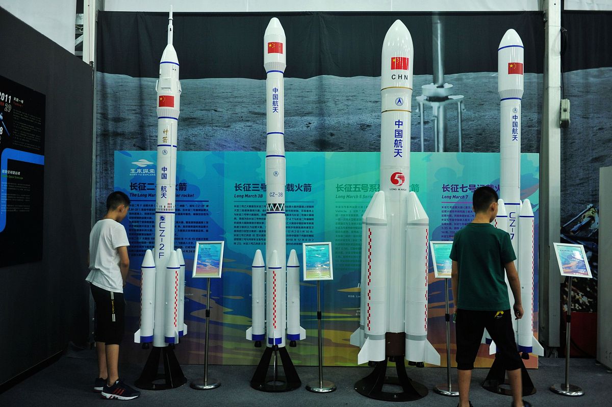 2019年8月14日,山东青岛金沙滩啤酒城,两位小学生在观看卫星发射火箭.