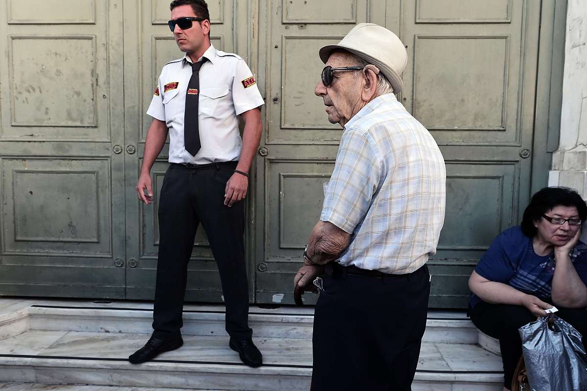 ***_***elderly people wait outside a bank prior its opening on j
