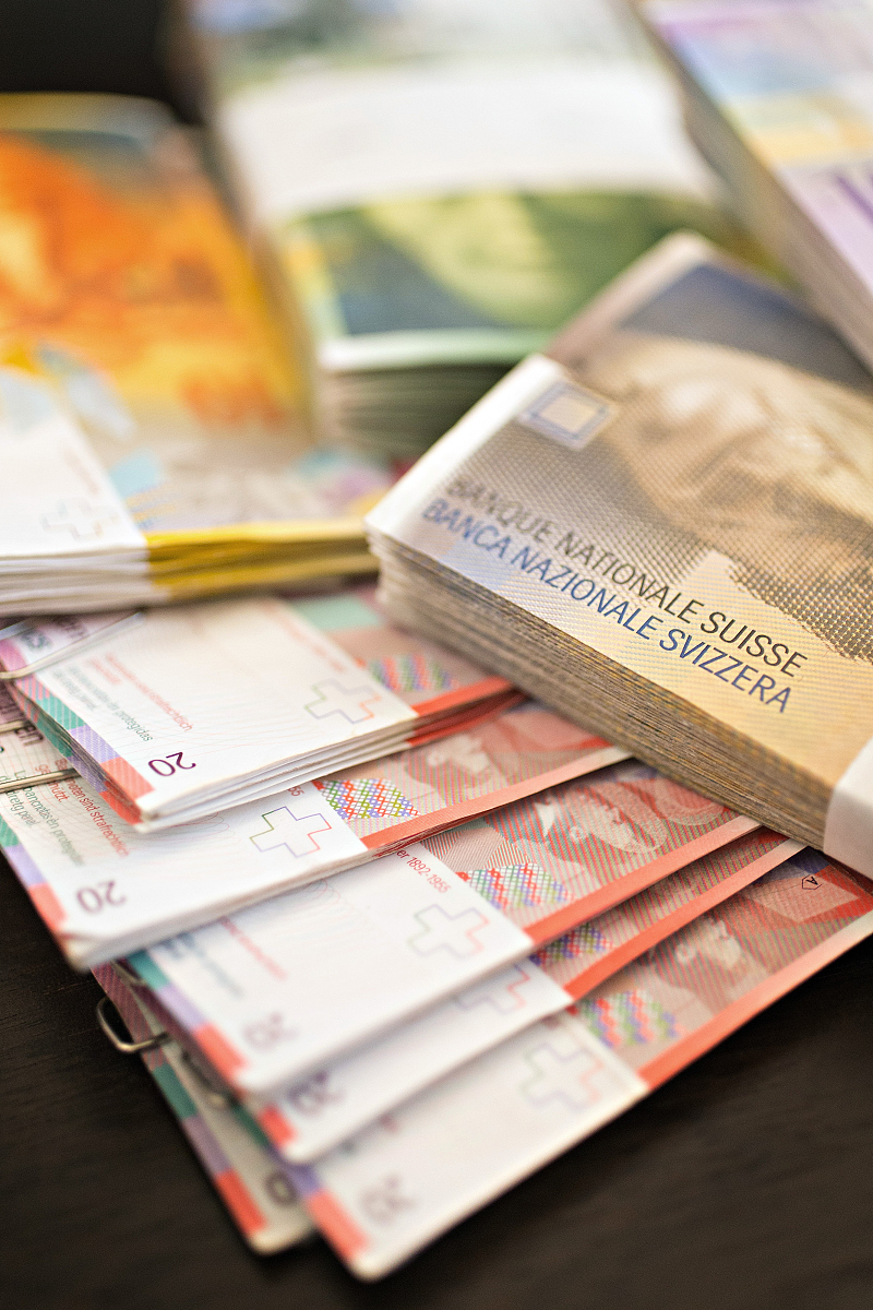swiss franc banknotes sit in the office of a bank in this arrang