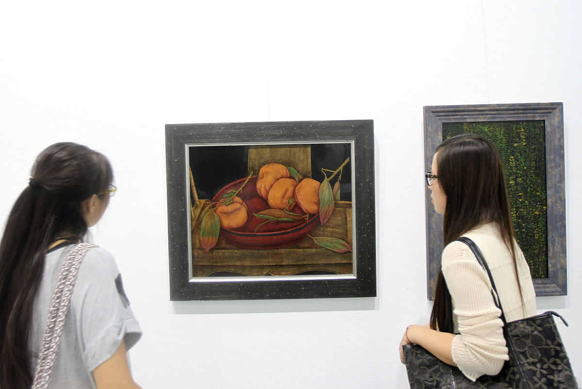   2013年9月5日 ,江苏南通,参观者观看漆画作品《漆盘中的柿子》.