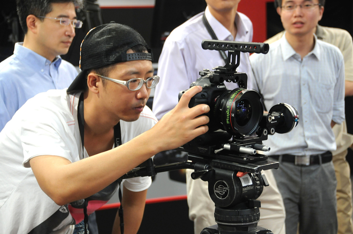 2013年8月21日,北京,参观者体验一台佳能专业高清数字摄影机"1dc".