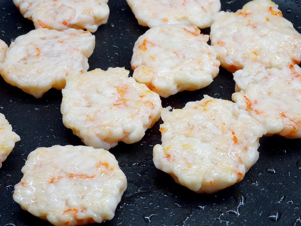 图为虾饼的制作过程 锅刷一层油,小火放入虾饼煎制,反复翻面.