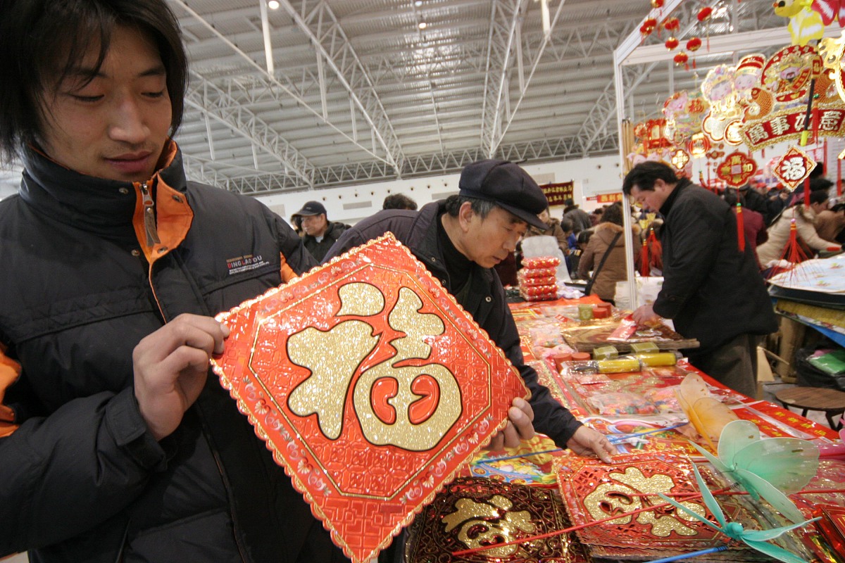 2007年2月1日,北京春节年货商品采购交易会开幕,市民在购买对联,"福"