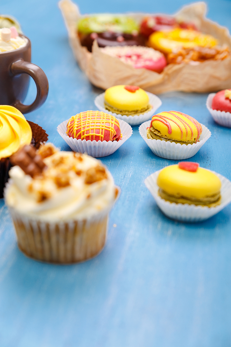 cupcakes, macaroons and donuts. mug with cream.