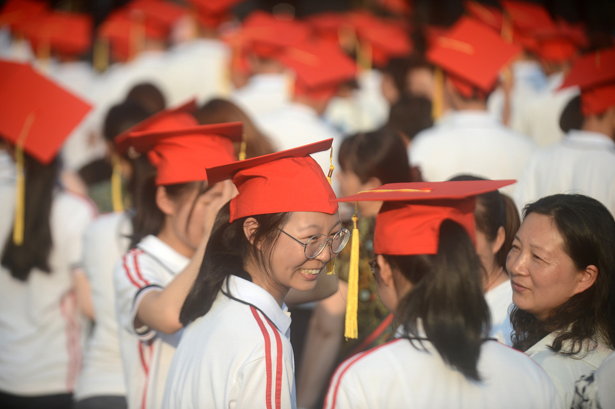 ***_***20<strong>1</strong>8年6月15日,在江苏扬州第一中学成人礼上,家长为孩子佩戴"