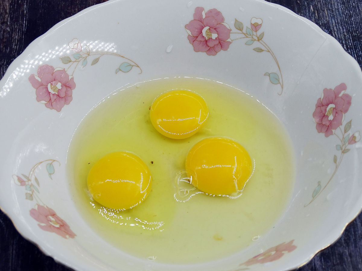 图为秋葵炒蛋的制作过程 鸡蛋打入碗中.