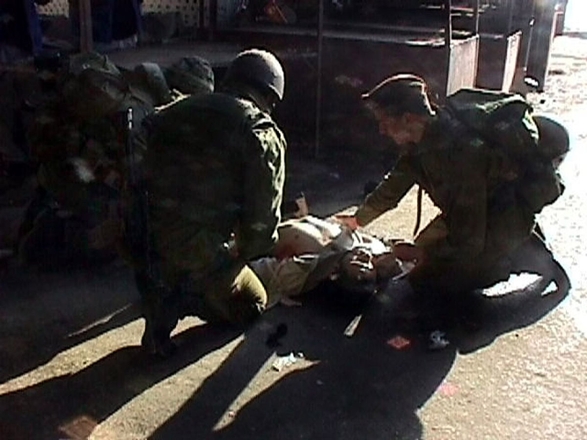 israeli soldiers on the scene performing first aid minutes after