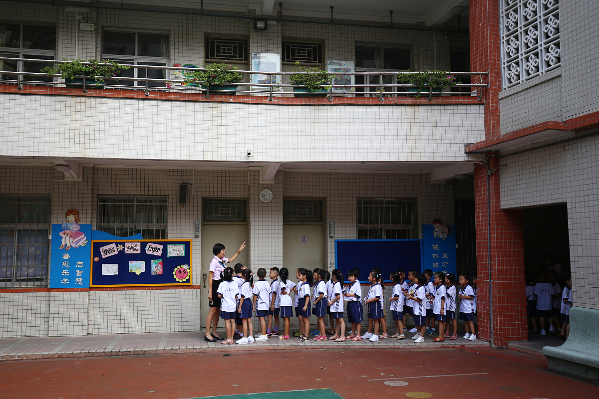 2015年08月23日,广州,大南路小学一年级新生穿着崭新的校服,牵着爸爸