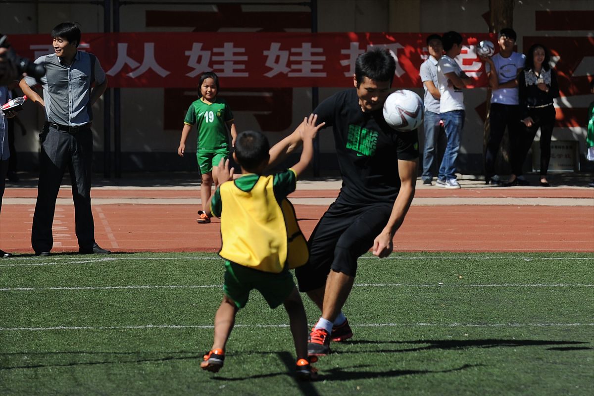 2014年9月15日,北京,国安球员走进平谷区第八小学与同学们一同踢球.**