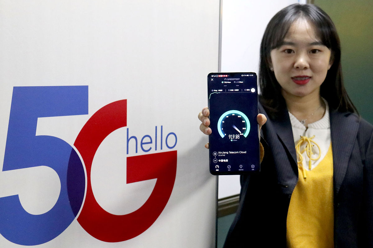 2020年1月2日,乌鲁木齐,中国电信新疆公司工作人员在展示5g手机下载速