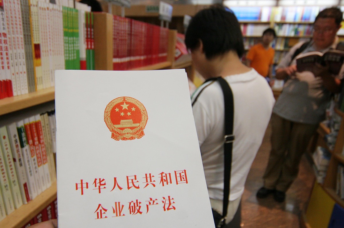 2007年6月1日,北京,市民在新华书店查阅《企业破产法》.+++_+++企业破