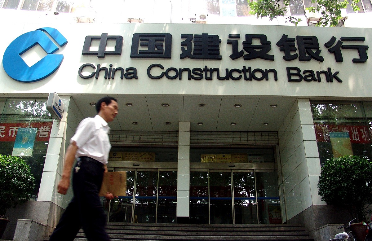 2005年8月1日,一位市民从郑州街头的中国建设银行网点门前走过.+++_++