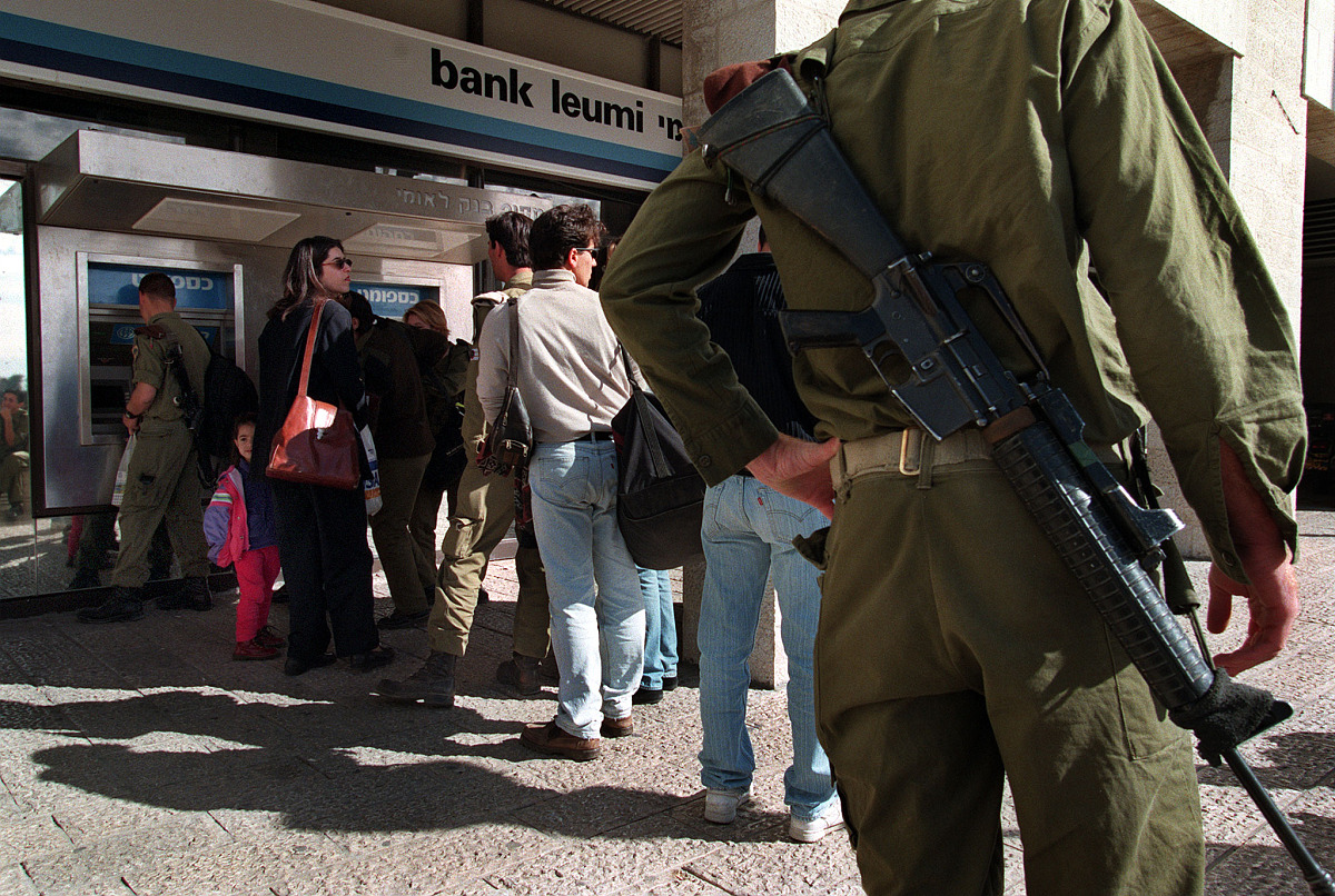 israeli soldiers and civilians line up at a bank cash machine de