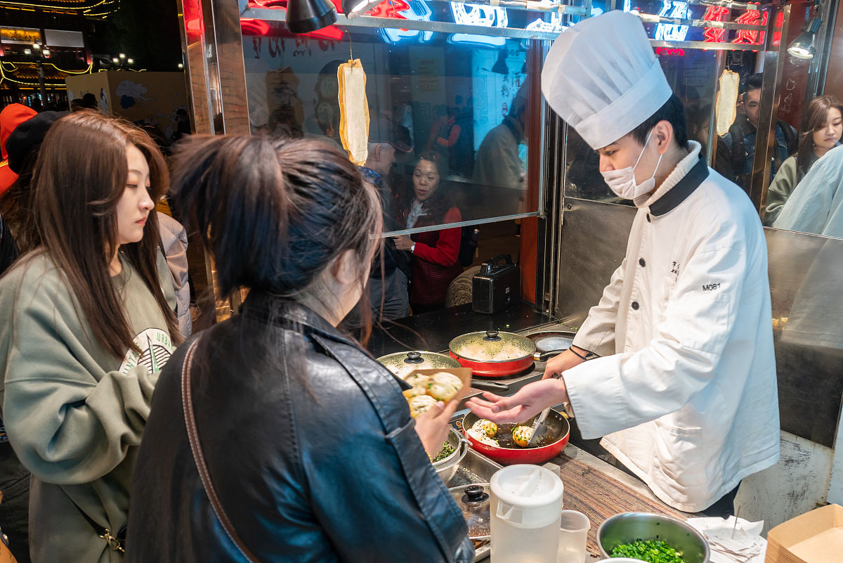 2019年12月8日,上海,当日晚间,豫园商城内一家打着"上海生煎"的店铺门