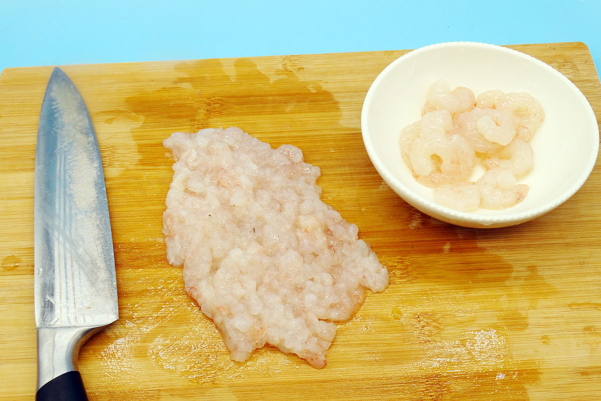 图为虾仁豆腐酿丝瓜的制作过程 留几个大虾仁,剩下的用刀剁成虾仁碎.