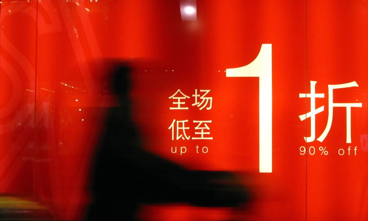 2011年3月16日,上海,行人从商店打出的促销广告前走过.+++_+++居民消