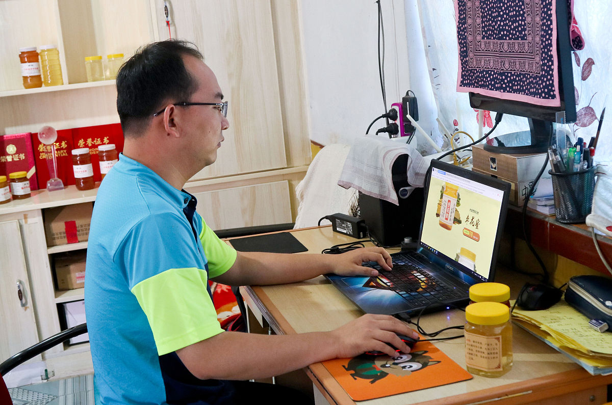 2019年8月13日,甘肃张掖,刘志忠在自己"最炫西北蜂"淘宝店上看看客户