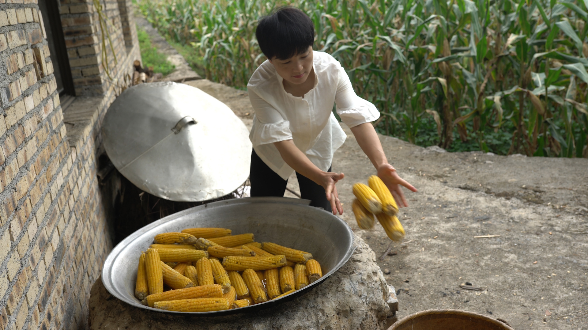 第二茬新鲜玉米熟了,农村媳妇掰了两箩筐,柴火煮一大锅是要做啥