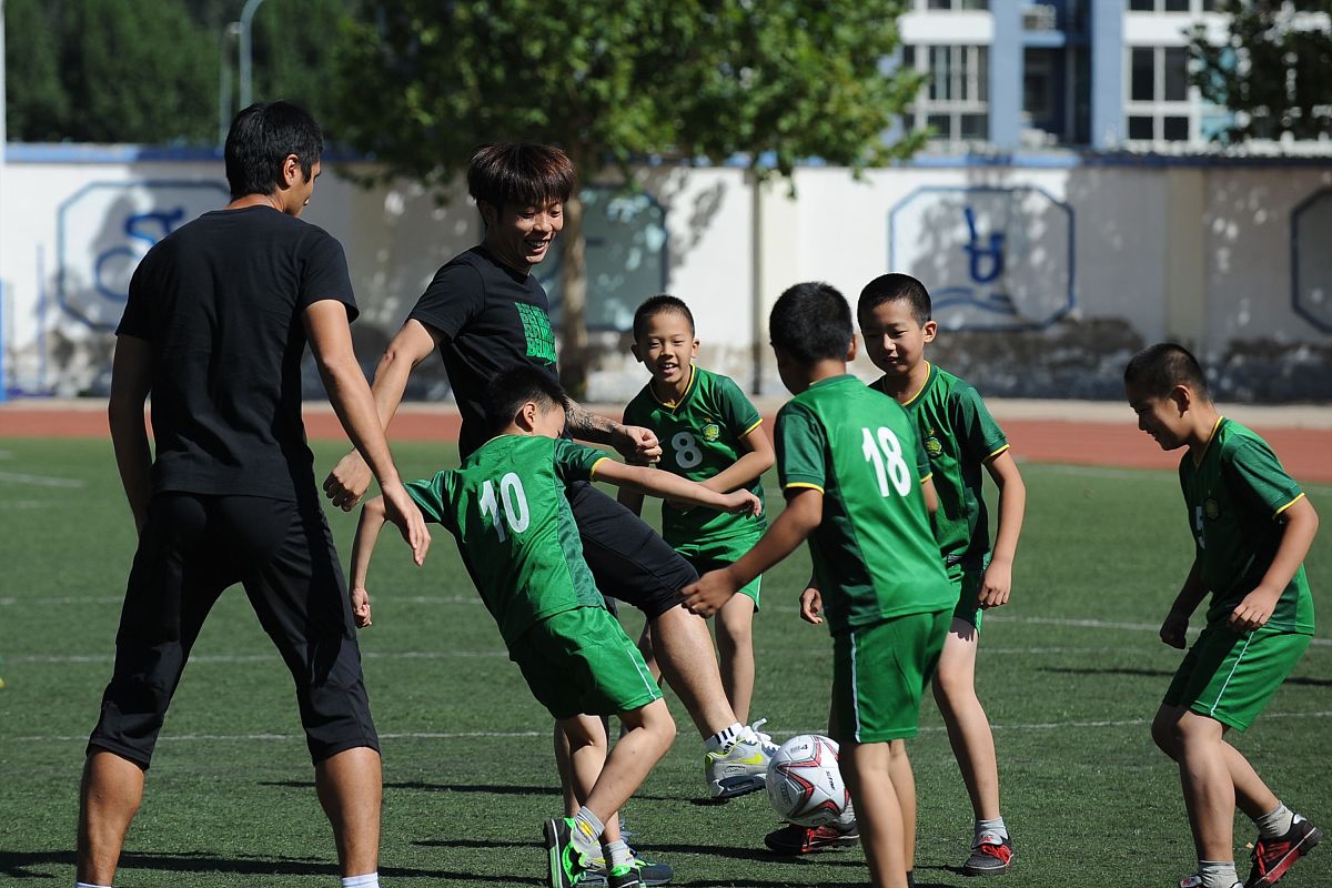 2014年9月15日,北京,国安球员走进平谷区第八小学与同学们一同踢球.**