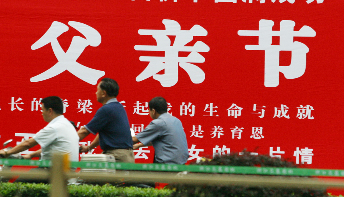 2006年6月14日下午,杭州延安路上路人匆匆走过一幅大型商业广告前.就