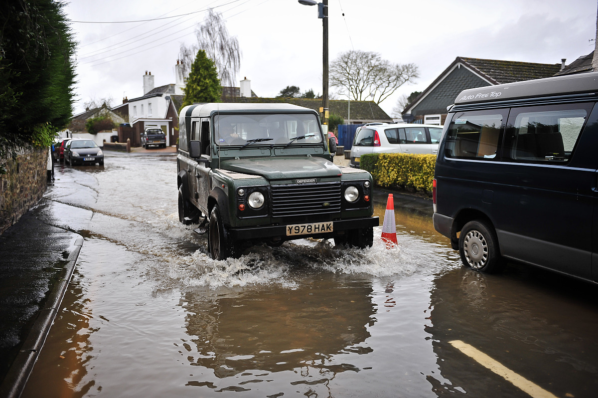 当地时间2012年12月23日,英国德文郡,洪水淹没街道.***_***a vehicle 