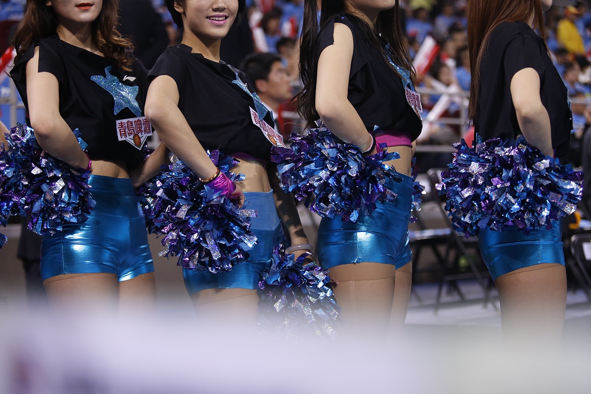 场景描述：一个穿短裤的亚洲女人赤着上身在大街上跳舞