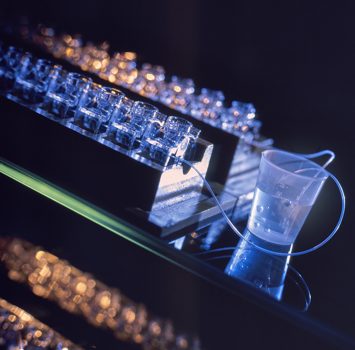 按照SCI要去润色这段话：The TmHoYAG crystal rod is placed in a glass tube and cooled by water at 12 ℃ Deionized water flow though bonded copper heat sink to regulate the temperature of LD arrays which is maintai