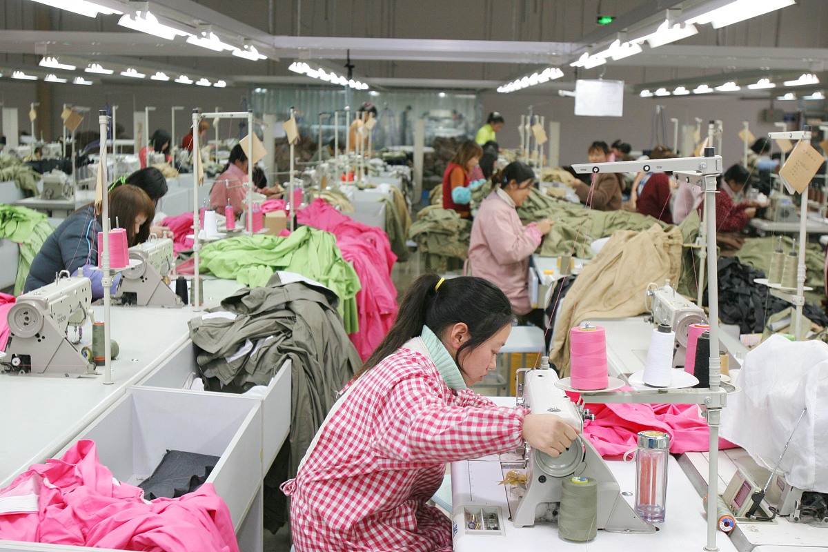 ***_***  2009年1月3日,工人在江苏南通一服装企业生产车间忙碌.   ++