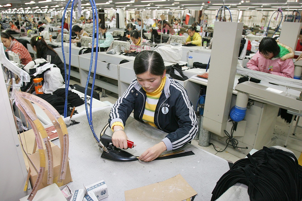 ***_***  2009年1月3日,工人在江苏南通一服装企业生产车间忙碌. +++_