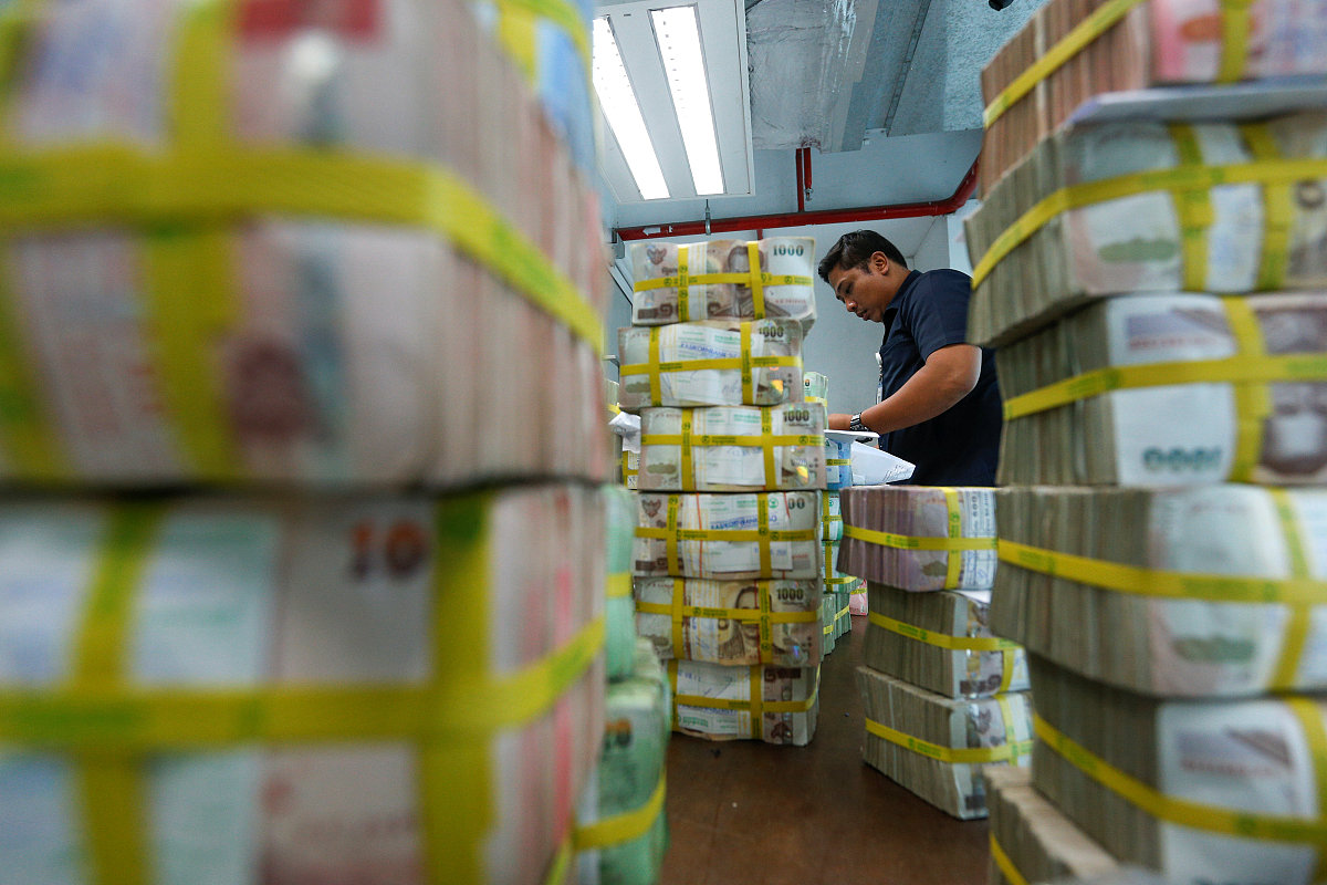 file photo : a bank employee gathers thai baht notes at a kasiko
