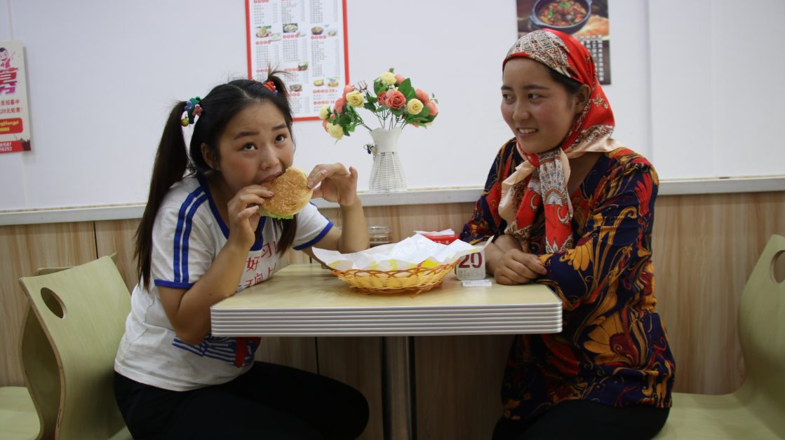 妈妈带傻妞进城吃汉堡,傻妞大口享受汉堡的香味,妈妈却不舍得吃