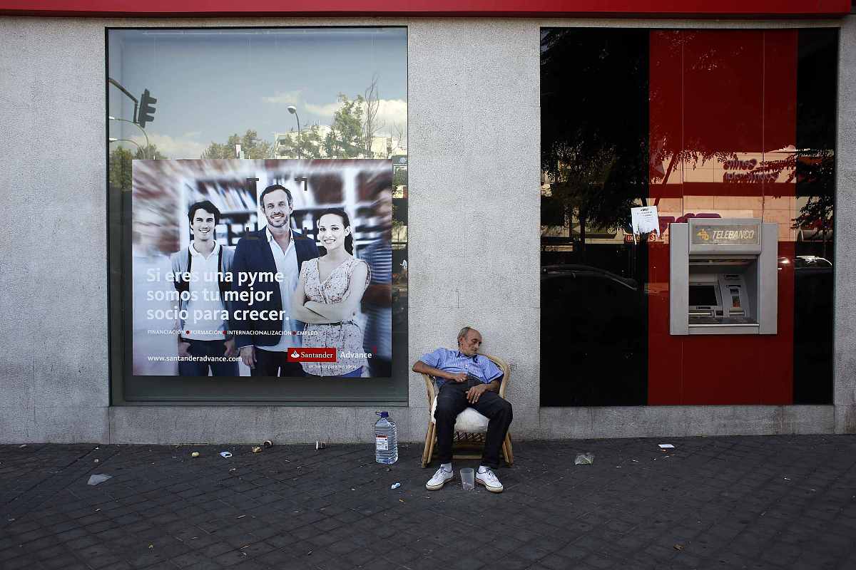a man takes a nap outside a bank branch as he asks for money on 