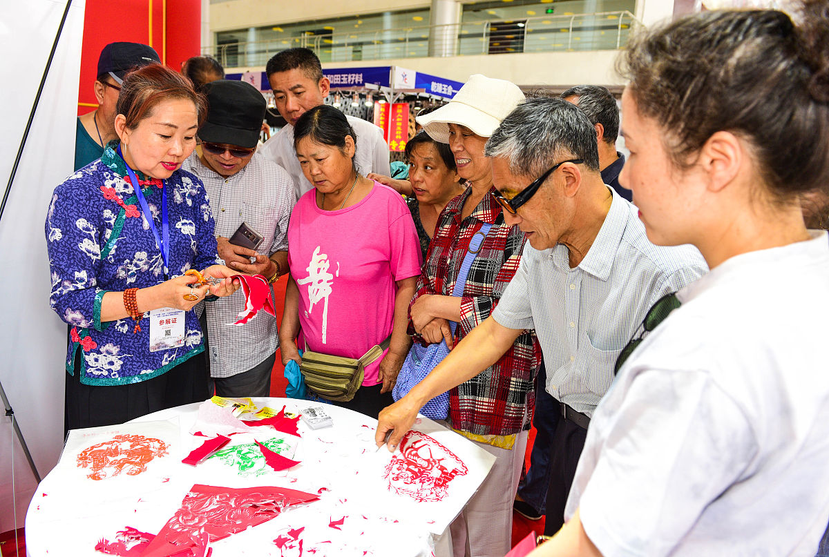 2018年6月15日,江苏扬州,展会上市民观看展览,玉器,漆器,瓷器等展品吸