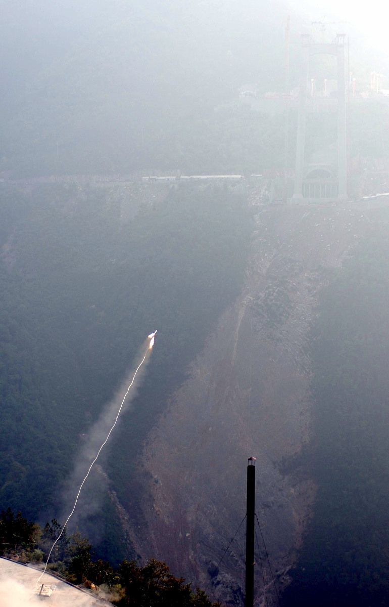 2006年10月9日,一枚小型火箭在湖北省巴东县四渡河西岸腾空而起,牵引