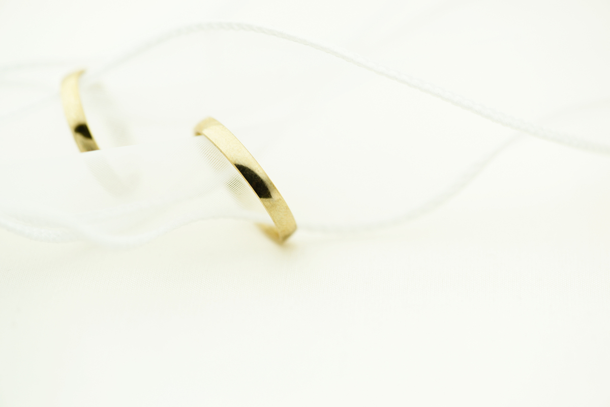请帮我把以下文字翻译成中文：The Cushion Band White MOP is an eternal band ring with custom hand cut and bezel set White Mother of Pearl all around the band to form the signature Tom Wood cushion shape White Mother