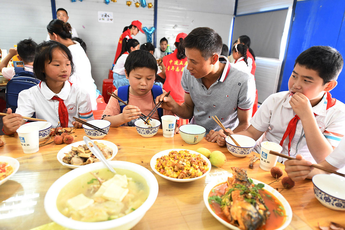 2019年6月13日,安徽阜阳,留守学生和家长以及"代理家长"一起吃上免费