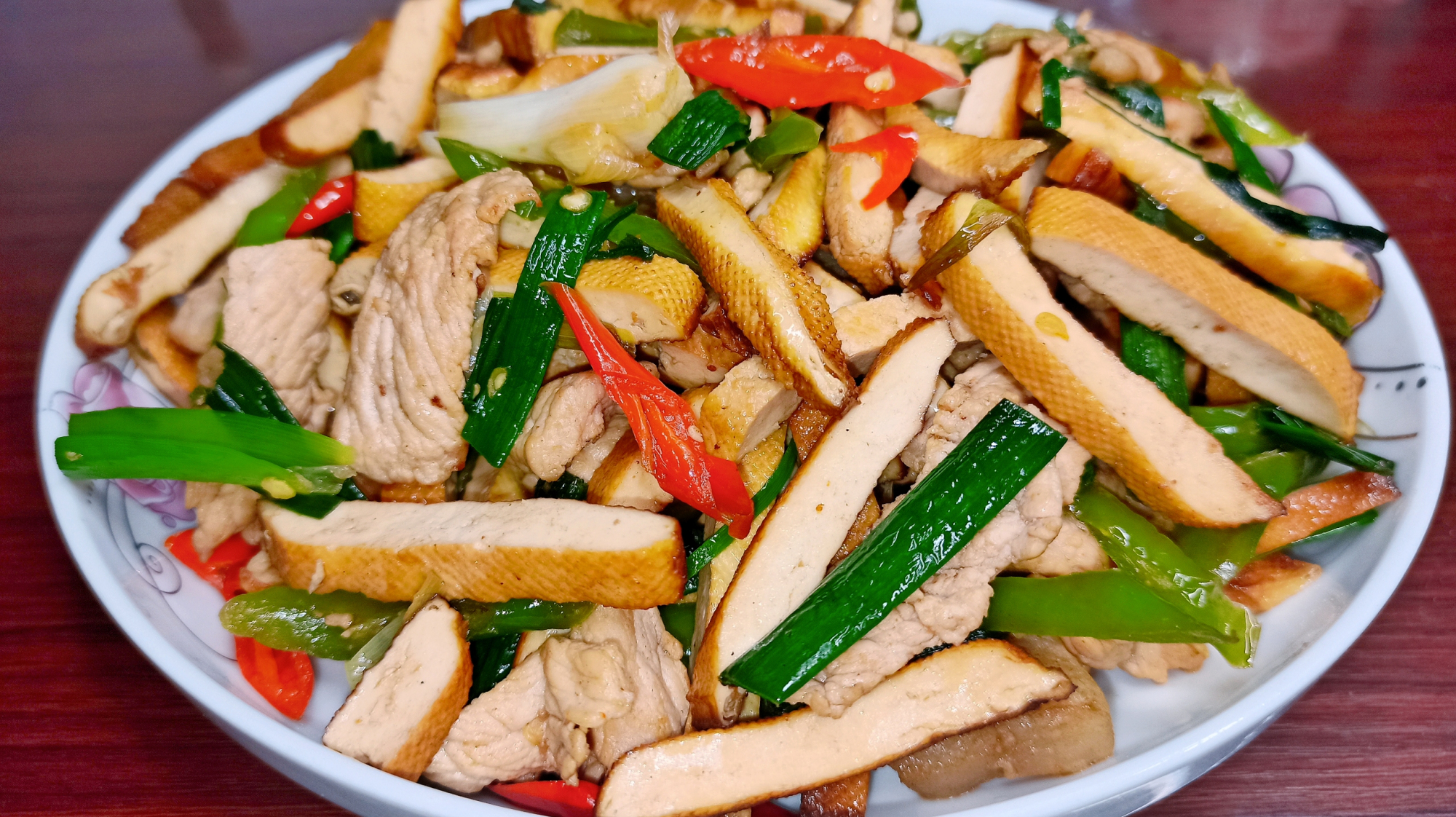 湖南大姐做了家常辣椒豆干炒肉,配上蒜苗,色香味俱全,好吃下饭