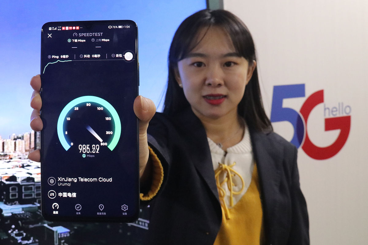 2020年1月2日,乌鲁木齐,中国电信新疆公司工作人员在展示5g手机下载速