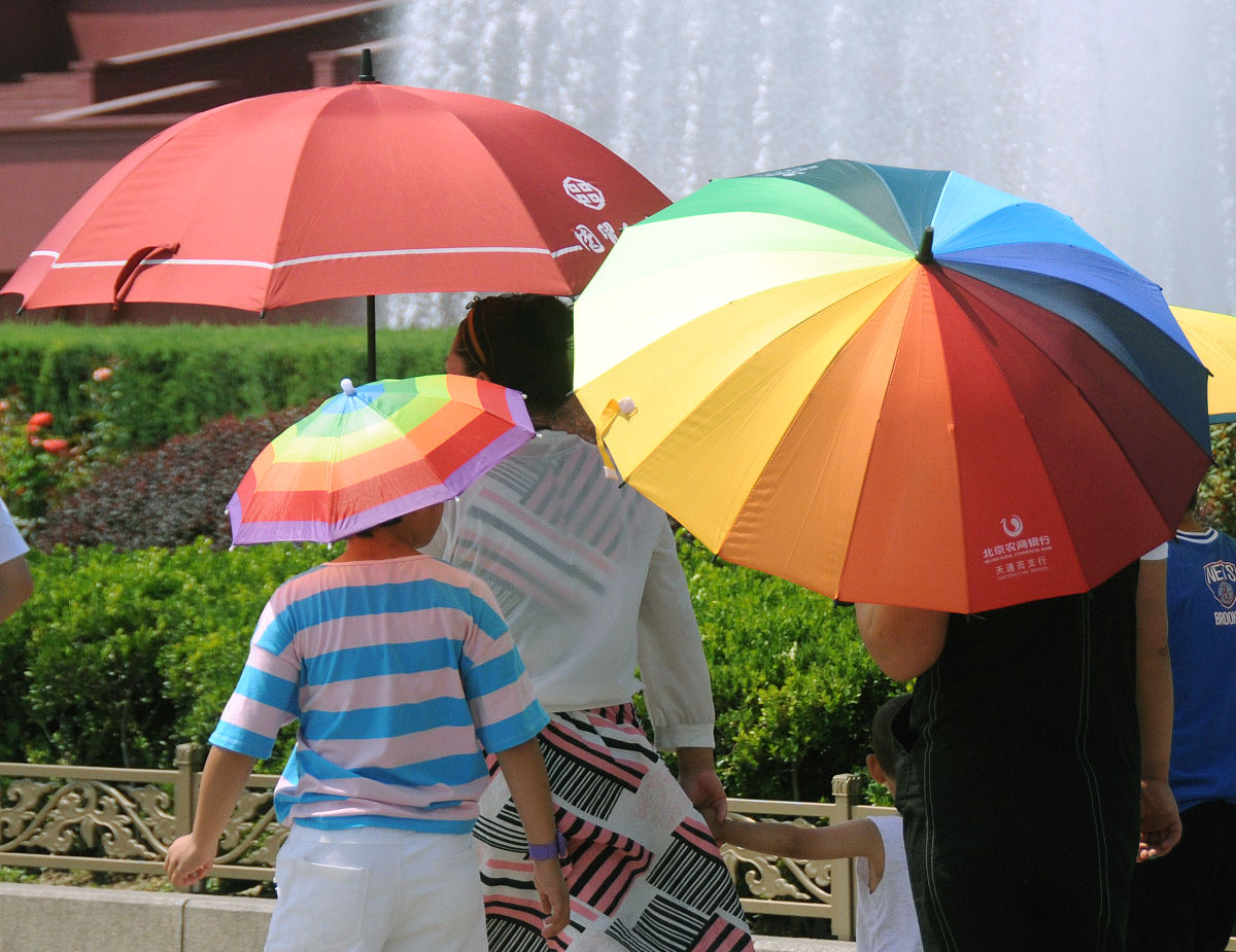 2019年7月25日,北京艳阳高照,热浪袭人,长安街的游客冒酷暑游览,并用