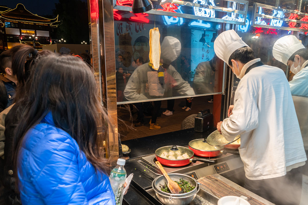 2019年12月8日,上海,当日晚间,豫园商城内一家打着"上海生煎"的店铺门